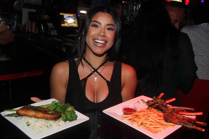 Server holding two big plates of food